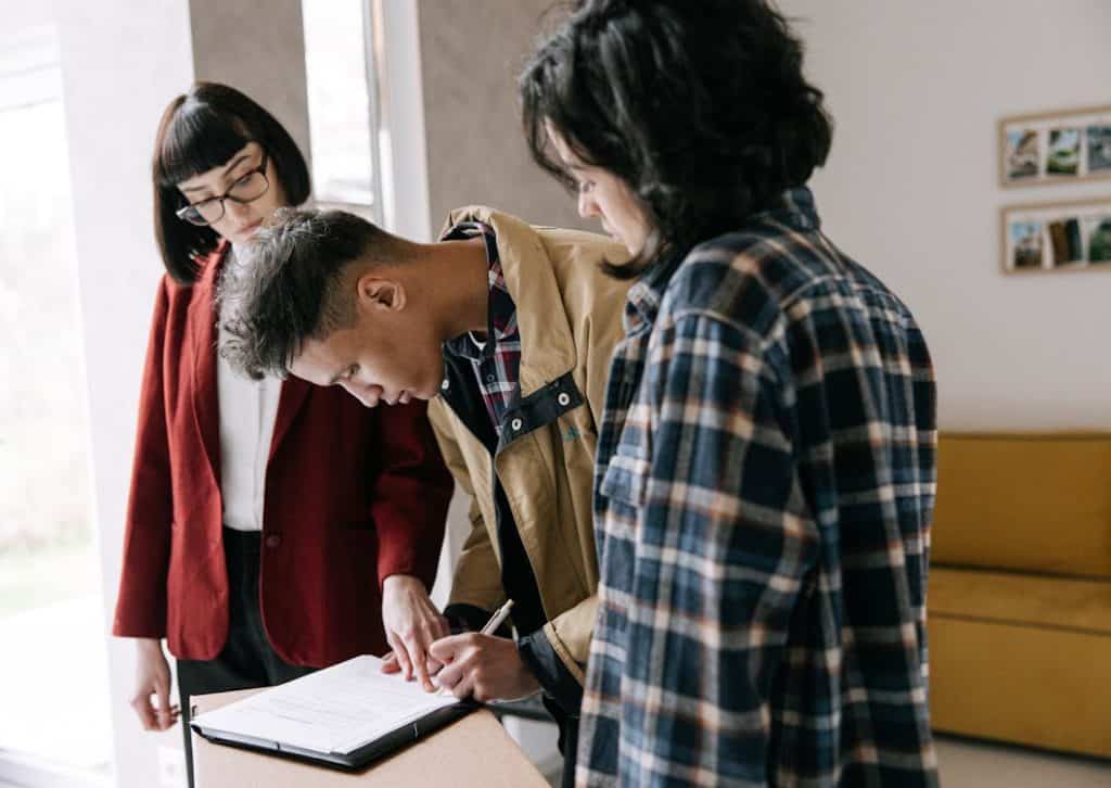 Couple signing a rental lease agreement with a property agent
